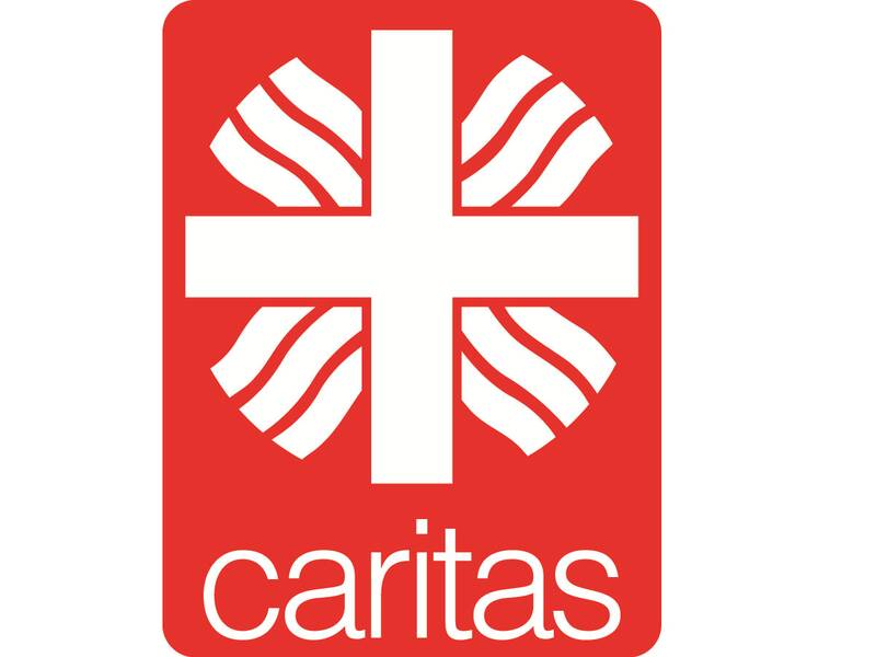 Ein rotes Logo zeigt ein weißes Kreuz mit geschwungenen Linien im Hintergrund und dem Wort "caritas" darunter.