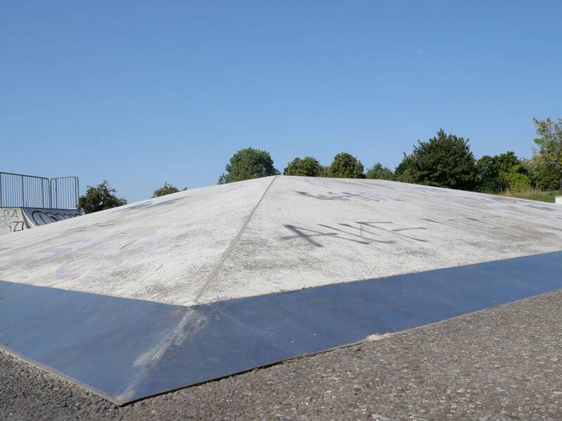 Eine niedrige, pyramidenförmige Rampe mit metallverstärkten Kanten, aufgenommen aus Bodennähe.