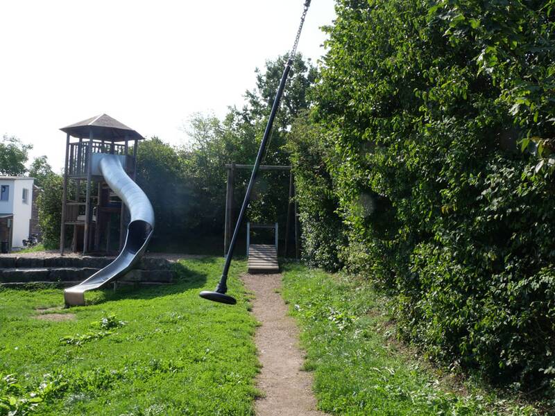 Eine Kinder-Seilbahn vor einem Spielturm mit Rutsche.