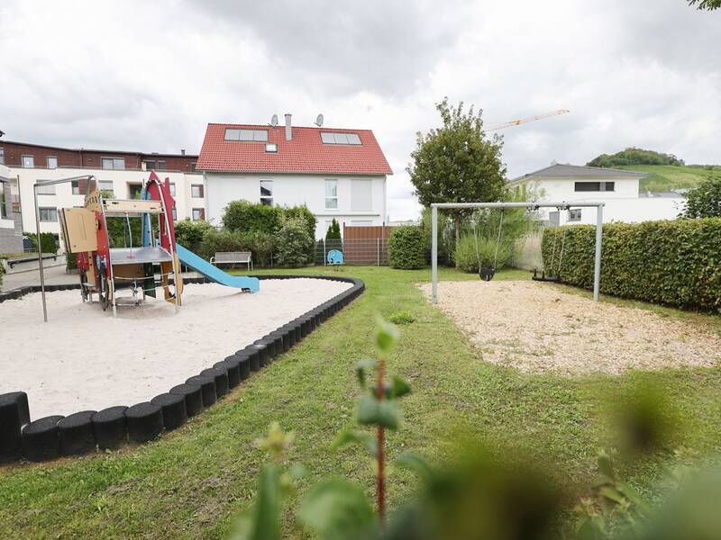 Spielplatz Weizenweg West, Blick auf Sandkasten und Schaukel