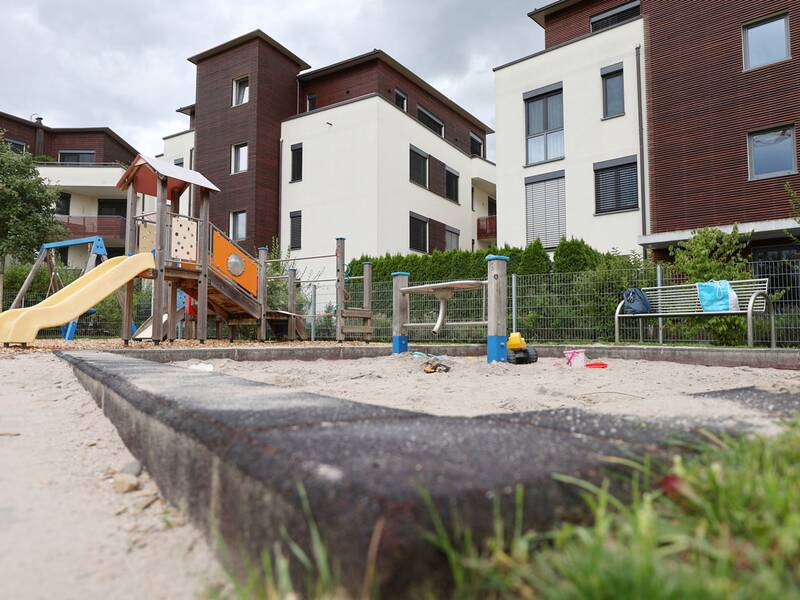 Spielplatz Weizenweg West, Blick auf den Sandkasten mit Spielhaus im Hintergrund