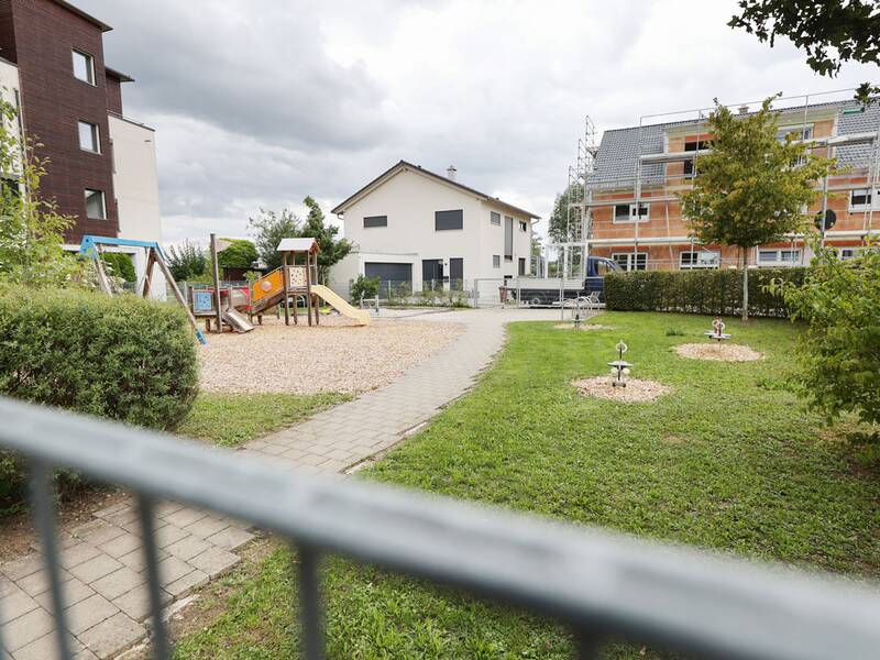 Spielplatz Weizenweg West, Blick auf den Spielplatz mit Schaukeltieren und Spielhaus