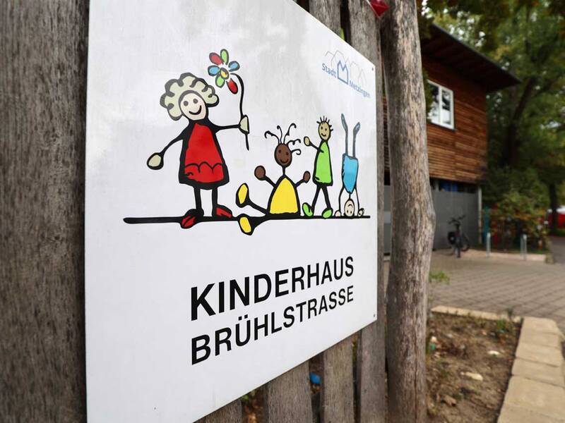 Das Schild „Kinderhaus Brühlstraße“ mit bunten Kinderfiguren begrüßt Besucher freundlich.