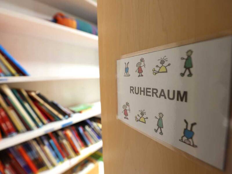 Türschild „Ruheraum“ neben einem Regal mit Büchern