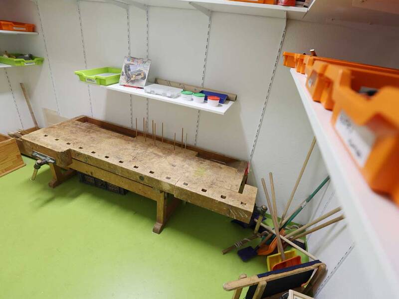 Eine robuste Holzwerkbank mit Werkzeugen und Bastelmaterial.