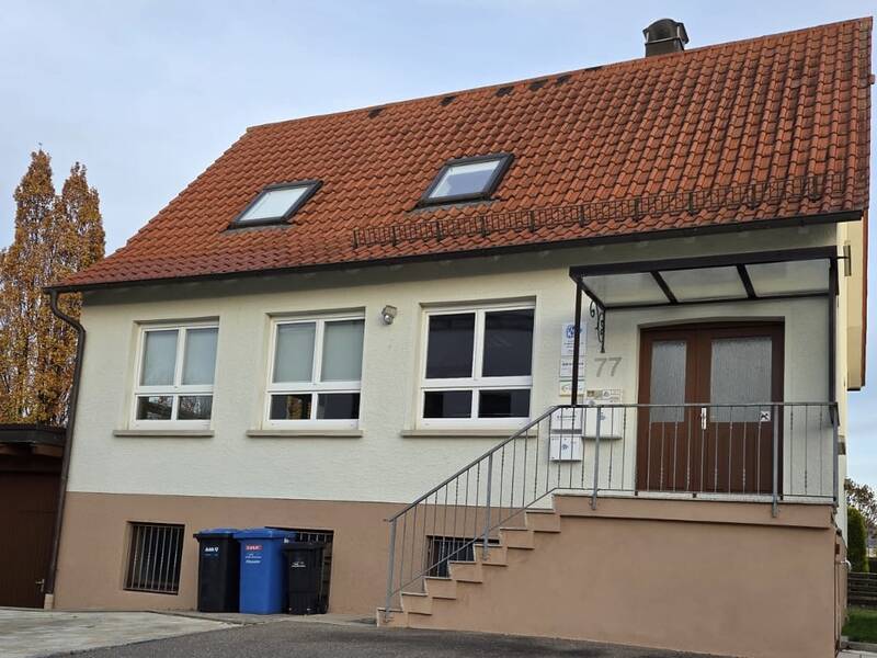 Einstöckiges Haus, eine Treppe führt zum Eingang.